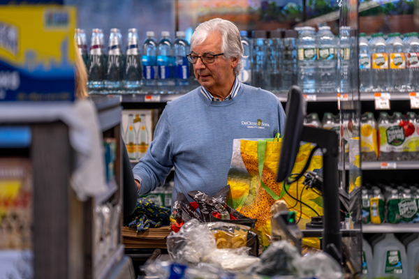 John DeCicco bagging groceries with paper and reusable bags